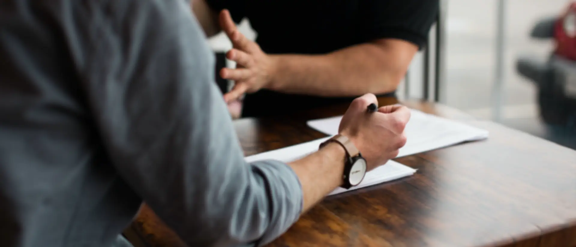 Reunión comercial de dos hombres para profundizar en la esencia de la venta y la conexión humana.
