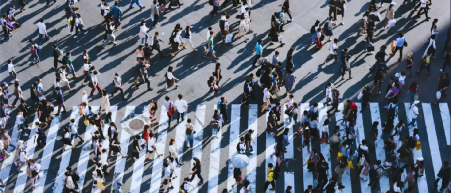 Multitud de personas cruzando un paso de peatones en una ciudad, simbolizando las oportunidades en la vida y en la venta consultiva y la importancia de la mentalidad para identificarlas
